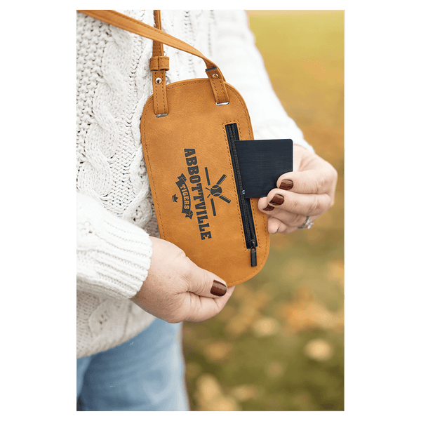 Close-up of a person wearing a tan custom phone bag, pulling a black card from the side zipper pocket.