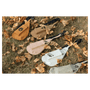 Five crossbody bags in orange, brown, beige, white, and grey lying flat on dry grass and fallen autumn leaves.